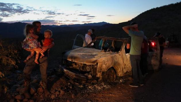 Members of the LeBaron family look at the burned car where part of the nine murdered members of the family were killed and burned during an ambush in Bavispe, Sonora mountains, Mexico, on November 5. (Herika Martinez / AFP)