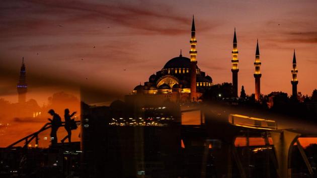 People cross the Halic Bridge over the golden horn as Suleymaniye mosque is seen in the background during sunset over the historical Eminonu district in Istanbul, Turkey. (Yasin Akgul / AFP)
