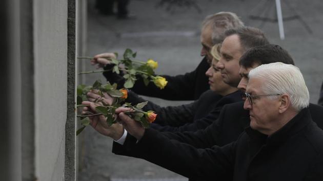 (R-L) The Presidents Frank-Walter Steinmeier of Germany, Janos Ader of Hungary, Andrzej Duda of Poland, Zuzana Caputova of Slovakia and Milos Zeman of the Czech Republic, put flowers in a crack inside the Berlin Wall during a commemoration ceremony to celebrate the 30th anniversary of the fall of the Berlin Wall at the Wall memorial site at Bernauer Strasse. (Markus Schreiber / AP)