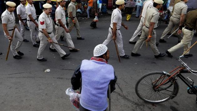 A Muslim man looks on as police officers conduct a flag march in a street outside Jama Masjid, before Supreme Court's verdict on a disputed religious site claimed by both majority Hindus and Muslim in Ayodhya, in the old quarters of Delhi.(REUTERS) A Muslim man looks on as police officers conduct a flag march in a street outside Jama Masjid, before Supreme Court's verdict on a disputed religious site claimed by both majority Hindus and Muslim in Ayodhya, in the old quarters of Delhi.(REUTERS)