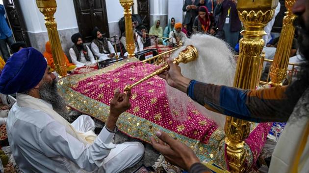 Sikh pilgrims take part in a religious ritual at the Shrine of Baba Guru Nanak Dev. Camera and laptop were not allowed to carry with first jatha going to Kartarpur. Only mobile phones were permitted. Leaders of various political parties arrived at passengers’ terminal to go with first jatha. (Aamir Qureshi / AFP) 