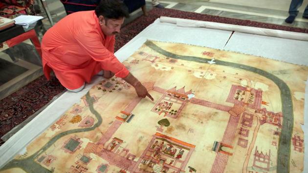 Ramu Ramdev, OSD at the City Palace, points out at Lord Rama’s birthplace in an old dilapidated map of Ayodhya being taken out from archives of erstwhile royal family of Jaipur, at City Palace, in Jaipur. On September 30, 2010, Allahabad High Court led by a three-judge bench partitioned the 2.77 acres of land in three equal parts between the the Sunni Waqf Board, the Nirmohi Akhara and Ram Lalla. (Himanshu Vyas / HT File)