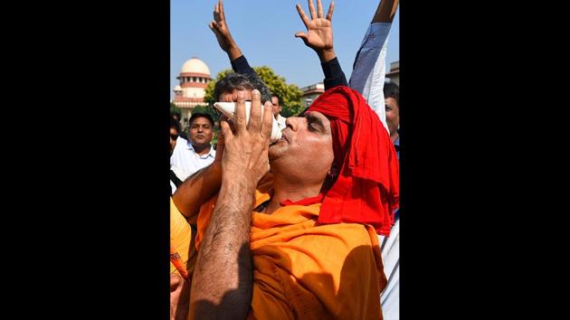 Hindu devotee blows the conch in celebration after the verdict in the Ram Janmabhoomi Babri Masjid case at Supreme Court in New Delhi. The Supreme Court’s Ayodhya verdict ruled in favour of a temple in the Ram Janmabhoomi-Babri Masjid title dispute but also ordered the government to allot 5 acres to the Sunni Central Waqf Board out of the 68 acres acquired by the Centre or by the state within the city of Ayodhya. (Sanchit Khanna / HT Photo) Hindu devotee blows the conch in celebration after the verdict in the Ram Janmabhoomi Babri Masjid case at Supreme Court in New Delhi. The Supreme Court’s Ayodhya verdict ruled in favour of a temple in the Ram Janmabhoomi-Babri Masjid title dispute but also ordered the government to allot 5 acres to the Sunni Central Waqf Board out of the 68 acres acquired by the Centre or by the state within the city of Ayodhya. (Sanchit Khanna / HT Photo)