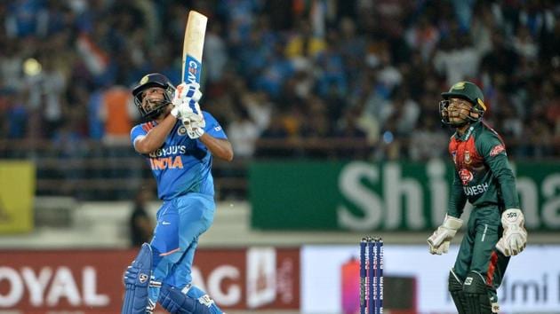 Indian team captain Rohit Sharma (L) plays a shot as Bangladeshi wicketkeeper Mustafizur Rehman looks on during the 2nd T20 International cricket match of three-match series between Bangladesh and India, at the Saurashtra Cricket Association Stadium in Rajkot. (Sajjad HUSSAIN / AFP) Indian team captain Rohit Sharma (L) plays a shot as Bangladeshi wicketkeeper Mustafizur Rehman looks on during the 2nd T20 International cricket match of three-match series between Bangladesh and India, at the Saurashtra Cricket Association Stadium in Rajkot. (Sajjad HUSSAIN / AFP)
