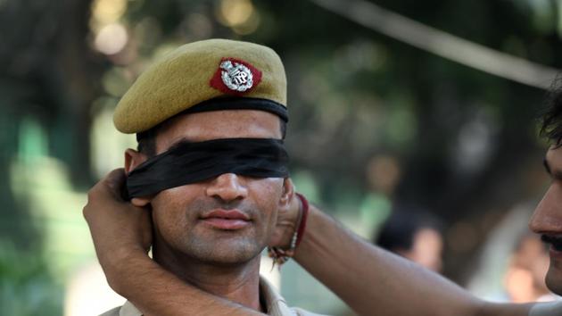 A Delhi Police personnel seen blindfolded during a protest outside the Delhi Police headquarters, at ITO, in New Delhi. Dozens of police personnel marched to the Delhi police headquarters at ITO on Tuesday morning to protest their leadership’s handling of recent instances of policemen being assaulted during clashes with lawyers since Saturday. (Raj K Raj / HT Photo) A Delhi Police personnel seen blindfolded during a protest outside the Delhi Police headquarters, at ITO, in New Delhi. Dozens of police personnel marched to the Delhi police headquarters at ITO on Tuesday morning to protest their leadership’s handling of recent instances of policemen being assaulted during clashes with lawyers since Saturday. (Raj K Raj / HT Photo)