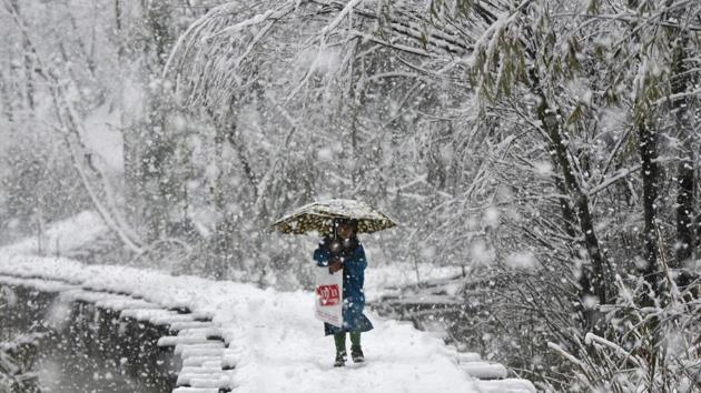 A girl walks on a snow covered foot bridge during the first snowfall of the season in the interiors of Dal Lake, Srinagar. The winds blowing from the Mediterranean Sea and their interaction with Maha Cyclone brought the first snowfall of the season in higher reaches of Kashmir on Wednesday, bringing down the temperature across the Himalayan Valley. (Waseem Andrabi / HT Photo) A girl walks on a snow covered foot bridge during the first snowfall of the season in the interiors of Dal Lake, Srinagar. The winds blowing from the Mediterranean Sea and their interaction with Maha Cyclone brought the first snowfall of the season in higher reaches of Kashmir on Wednesday, bringing down the temperature across the Himalayan Valley. (Waseem Andrabi / HT Photo)