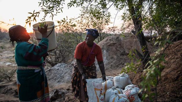 Phephu Mchavi, 62, (L) and Ndaheni Mashele, 66, (R) fill bags with salt. Before they begin their work, the women make offerings of tobacco, coins and mqombothi -- a traditional sorghum malt beer -- at the base of a nearby leadwood tree, to solicit the help of the spirits. “If you don’t start by asking, you stand a chance of not even getting any salt,” warned Ndaheni Mashele another harvester. (Michele Spatari / AFP) Phephu Mchavi, 62, (L) and Ndaheni Mashele, 66, (R) fill bags with salt. Before they begin their work, the women make offerings of tobacco, coins and mqombothi -- a traditional sorghum malt beer -- at the base of a nearby leadwood tree, to solicit the help of the spirits. “If you don’t start by asking, you stand a chance of not even getting any salt,” warned Ndaheni Mashele another harvester. (Michele Spatari / AFP)
