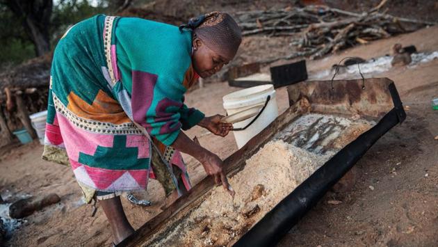 Phephu Mchavi, 62, scratches salt from a metal pan. The concoction of river sand, salty soil and water is filtered up to four times until the colour of the water is almost clear. When the foam hardens, it crystallises, forming the precious salt. The women sell the bulk of it to Muller’s NGO, which then sells it to a company called Oryx, which in turn retails it to top-end restaurants. (Michele Spatari / AFP) Phephu Mchavi, 62, scratches salt from a metal pan. The concoction of river sand, salty soil and water is filtered up to four times until the colour of the water is almost clear. When the foam hardens, it crystallises, forming the precious salt. The women sell the bulk of it to Muller’s NGO, which then sells it to a company called Oryx, which in turn retails it to top-end restaurants. (Michele Spatari / AFP)