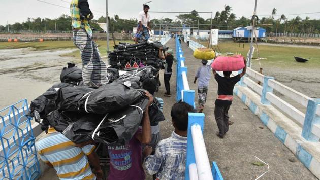 People carry tarpaulin for residents of Gangasagar Island distributed by the state government in the aftermath of cyclone Bulbul. Many houses collapsed in Ramnagar, Nandigram, Khejuri and Haldia and 22,000 people were shifted to rescue centres. (Samir Jana / HT Photo) People carry tarpaulin for residents of Gangasagar Island distributed by the state government in the aftermath of cyclone Bulbul. Many houses collapsed in Ramnagar, Nandigram, Khejuri and Haldia and 22,000 people were shifted to rescue centres. (Samir Jana / HT Photo)