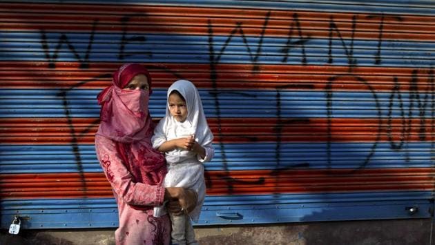 A protestor Jawahira Banoo carries her 3-year-old daughter Rutba outside a closed shop with a spray-painted graffiti after a protest on the outskirts of Srinagar. Banoo says she does not miss an opportunity to come out to the streets to protest. The men are at a higher risk of being detained, she says. (Dar Yasin / AP) A protestor Jawahira Banoo carries her 3-year-old daughter Rutba outside a closed shop with a spray-painted graffiti after a protest on the outskirts of Srinagar. Banoo says she does not miss an opportunity to come out to the streets to protest. The men are at a higher risk of being detained, she says. (Dar Yasin / AP)