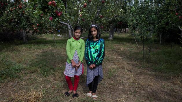 Twin sisters Tabeer Shafi Bhat (R) and Taseer Shafi Bhat at an apple orchard in Wuyan, south of Srinagar. The girls said that they’ve had nothing to do since the lockdown started on August 5 and they miss going to school. Authorities encouraged students to return to school but parents have largely remained unwilling to send their kids to educational institutes due to the restrictions in place. (Dar Yasin / AP) Twin sisters Tabeer Shafi Bhat (R) and Taseer Shafi Bhat at an apple orchard in Wuyan, south of Srinagar. The girls said that they’ve had nothing to do since the lockdown started on August 5 and they miss going to school. Authorities encouraged students to return to school but parents have largely remained unwilling to send their kids to educational institutes due to the restrictions in place. (Dar Yasin / AP)