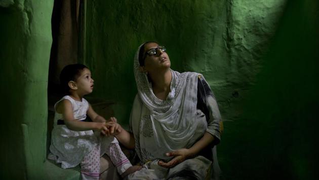 Sumaira Bilal, wife of detainee Bilal Ahmed, talks to her two-year-old daughter as they sit for photographs on a staircase of their house in Srinagar. Ahmed was detained on the night of August 5, following the abrogation of Article 370 and stripping Kashmir of its statehood. Sumaira says her daughter points to the window often and calls for her father “Baba, Baba, when are you coming back?” (Dar Yasin / AP) Sumaira Bilal, wife of detainee Bilal Ahmed, talks to her two-year-old daughter as they sit for photographs on a staircase of their house in Srinagar. Ahmed was detained on the night of August 5, following the abrogation of Article 370 and stripping Kashmir of its statehood. Sumaira says her daughter points to the window often and calls for her father “Baba, Baba, when are you coming back?” (Dar Yasin / AP)