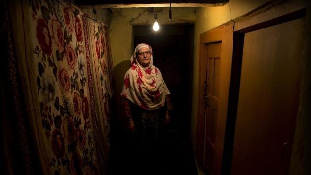 Ateeqa Begum, mother of a 22-year-old Kashmiri detainee Fasil Aslam Mir, stands inside her house in Srinagar. Begum has lived alone ever since her only son Fasil, in his late twenties, was detained on his way home after fetching medicines for her. “My son has been shifted to a jail in an undisclosed city and I have no means to travel there to see him,” she said. (Dar Yasin / AP) Ateeqa Begum, mother of a 22-year-old Kashmiri detainee Fasil Aslam Mir, stands inside her house in Srinagar. Begum has lived alone ever since her only son Fasil, in his late twenties, was detained on his way home after fetching medicines for her. “My son has been shifted to a jail in an undisclosed city and I have no means to travel there to see him,” she said. (Dar Yasin / AP)