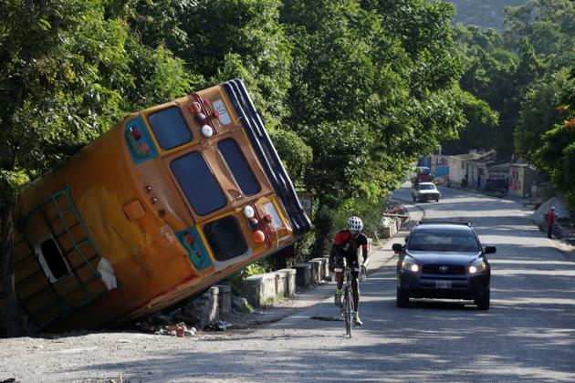 Shawel Lafontant, 22, a member of the Haiti national cycling team, cycles past a crashed bus during a training session. The country’s main arteries clogged with trucks and buses, along with roadblocks that have been set up as part of the anti-government protests that have paralyzed the country for months now, have made it even more dangerous for cyclists. (Alexandre Meneghini / REUTERS)