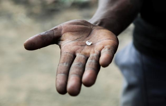 A miner holds an uncut diamond in his hand. Ekapa and Petra Diamonds PDL.L, then a part-owner of the mine, launched the initiative last year at Kimberley, hoping to address the problem. As much as 6 million rands’ ($400,300) worth of diamonds were being taken by illegal miners each month, Ekapa estimates. In a bid to stem that, the company formed 836 miners and gave them a licence to mine the fields. (Sumaya Hisham / REUTERS) A miner holds an uncut diamond in his hand. Ekapa and Petra Diamonds PDL.L, then a part-owner of the mine, launched the initiative last year at Kimberley, hoping to address the problem. As much as 6 million rands’ ($400,300) worth of diamonds were being taken by illegal miners each month, Ekapa estimates. In a bid to stem that, the company formed 836 miners and gave them a licence to mine the fields. (Sumaya Hisham / REUTERS)