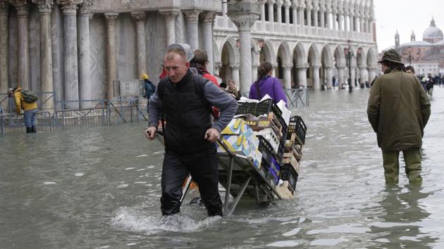 A greengrocer pulls his cart through high water in Venice. Environment Minister Sergio Costa blamed climate change and the “tropicalisation” of violent rainfall and strong winds. “This is what is happening more and more often in the Mediterranean,” Costa said on Facebook. “Global warming will destroy our planet if we do not immediately reverse the direction.” (Luca Bruno / AP) A greengrocer pulls his cart through high water in Venice. Environment Minister Sergio Costa blamed climate change and the “tropicalisation” of violent rainfall and strong winds. “This is what is happening more and more often in the Mediterranean,” Costa said on Facebook. “Global warming will destroy our planet if we do not immediately reverse the direction.” (Luca Bruno / AP)