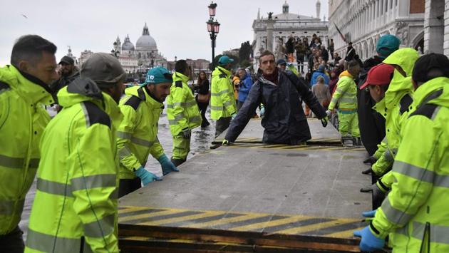 Volunteers set up a footbridge across the flooded Riva degli Schiavoni embankment on November 13. The exceptionally intense “acqua alta,” or high waters, peaked at 1.87 metres (six feet). Only once since records began in 1923 has the water crept even higher, reaching 1.94 metres in 1966. “It was unbelievable. The water rose so quickly,” said resident Tiziano Collarin, 59, as he surveyed the damage. (Marco Bertorello / AFP) Volunteers set up a footbridge across the flooded Riva degli Schiavoni embankment on November 13. The exceptionally intense “acqua alta,” or high waters, peaked at 1.87 metres (six feet). Only once since records began in 1923 has the water crept even higher, reaching 1.94 metres in 1966. “It was unbelievable. The water rose so quickly,” said resident Tiziano Collarin, 59, as he surveyed the damage. (Marco Bertorello / AFP)