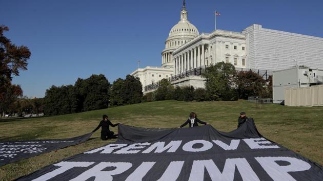Demonstrators kneel near large banners on the lawn adjacent to the U.S. Capitol, while a top U.S. diplomat in Ukraine William Taylor, and career Foreign Service officer George Kent, testify before the House Intelligence Committee on Capitol Hill in Washington, Wednesday, November 13. (AP) Demonstrators kneel near large banners on the lawn adjacent to the U.S. Capitol, while a top U.S. diplomat in Ukraine William Taylor, and career Foreign Service officer George Kent, testify before the House Intelligence Committee on Capitol Hill in Washington, Wednesday, November 13. (AP)