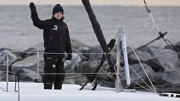 Swedish teen climate activist Greta Thunberg waves from the 48-foot (15-meter) catamaran La Vagabonde as it departs Salt Ponds in Hampton (VA), on November 13. Swedish teen climate activist Greta Thunberg hitched a renewable-energy ride back to Europe on Wednesday, sailing into the Atlantic on a trip she hopes will get her to Madrid in time for another climate conference. (Rob Ostermaier / The Virginian-Pilot / AP)
