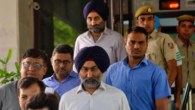 Police escort Malvinder Singh and his brother Shivinder Singh, former directors of Ranbaxy Laboratories, inside a court premises in New Delhi, India, October 11, 2019.(REUTERS File)