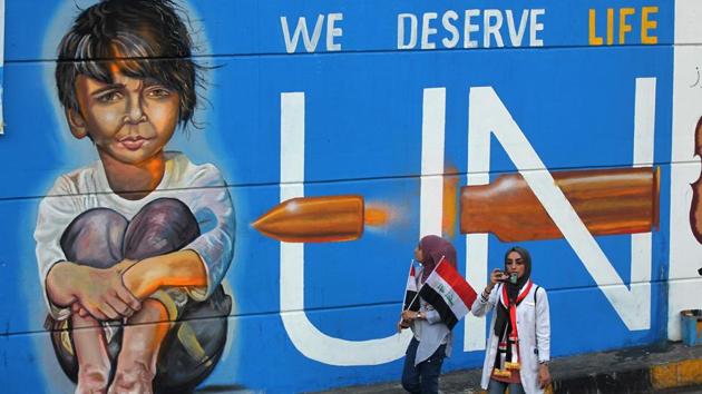 Iraqi demonstrators walk in front of a mural painting in the capital Baghdad's Tahrir square during ongoing anti-government demonstrations on November 13. Protests erupted on October 1 in an outpouring of anger over high unemployment and widespread corruption but have escalated into demands for root-and-branch reform of the political system. (AHMAD AL-RUBAYE / AFP)