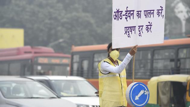 A civil defence personnel holds a placard to encourage residents to follow the odd-even scheme, at ITO crossing, in New Delhi. (Arvind Yadav/HT PHOTO) A civil defence personnel holds a placard to encourage residents to follow the odd-even scheme, at ITO crossing, in New Delhi. (Arvind Yadav/HT PHOTO)