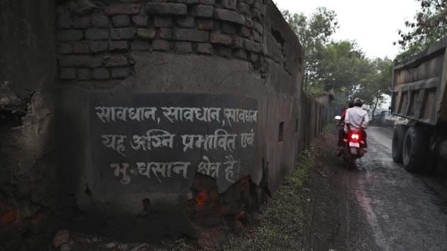 A motorist rides past a warning painted on a wall informing people about the burning coal mine zone and land subsidence near the village of Rajapur. Coal is an important contributor to India’s growth, supporting its iron and steel industries and generating more than half the country’s power. In Jharia, the heart of India’s coal industry, the livelihoods of half a million people depend on it. (Aijaz Rahi / AP) A motorist rides past a warning painted on a wall informing people about the burning coal mine zone and land subsidence near the village of Rajapur. Coal is an important contributor to India’s growth, supporting its iron and steel industries and generating more than half the country’s power. In Jharia, the heart of India’s coal industry, the livelihoods of half a million people depend on it. (Aijaz Rahi / AP)