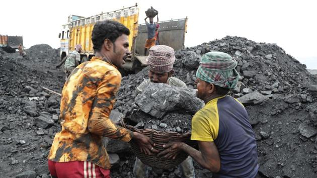 Workers lift a large basket filled with coal before loading it into a truck for transportation in Godhar village. (Aijaz Rahi / AP) Workers lift a large basket filled with coal before loading it into a truck for transportation in Godhar village. (Aijaz Rahi / AP)