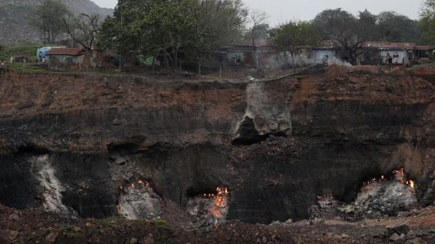 Village houses are seen above the glowing embers of an underground coal fire in the village of Bastakola. Decades of underground coal mining have hollowed Jharia’s land. The collapse of houses and other structures on the surface due to subsidence is increasingly common. Respiratory diseases like tuberculosis, bronchitis and asthma are common. Children have been born deformed, and some people have fallen into the raging fire pits and died. (Aijaz Rahi / AP) Village houses are seen above the glowing embers of an underground coal fire in the village of Bastakola. Decades of underground coal mining have hollowed Jharia’s land. The collapse of houses and other structures on the surface due to subsidence is increasingly common. Respiratory diseases like tuberculosis, bronchitis and asthma are common. Children have been born deformed, and some people have fallen into the raging fire pits and died. (Aijaz Rahi / AP)