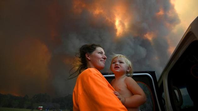 Sharnie Moren and her 18-month-old daughter Charlotte look on as thick smoke rises from bushfires near Nana Glen, near Coffs Harbour, Australia. The bushfire season has begun earlier than usual, in the southern hemisphere spring, and is expected to be long and brutal this year as a three-year drought has left broad swathes of Australia’s east and west more susceptible to fire. (AAP Image/Dan Peled / REUTERS)