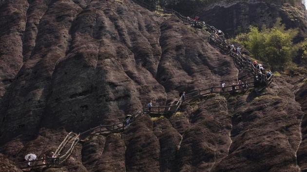 Visitors climb Tianyou peak in Wuyishan, Fujian. “It’s quite urgent as soon as possible to identify the places, the ecosystems and other natural features” to protect, Zhu says. Among other goals, China aims to build its own Yellowstone on the Tibetan plateau. (Ng Han Guan / AP)