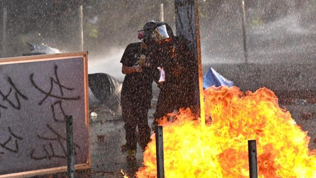 Protesters throw Molotov cocktails at the police who use water canon outside the Hong Kong Polytechnic University in Hong Kong. Protests have tremored through the global financial hub since June with many in the city of 7.5 million people venting fury at eroding freedoms under Chinese rule. China has repeatedly warned that it will not tolerate the dissent, and there have been concerns that Beijing could send in troops to put an end to the unrest.   (Philip FONG  / AFP) 