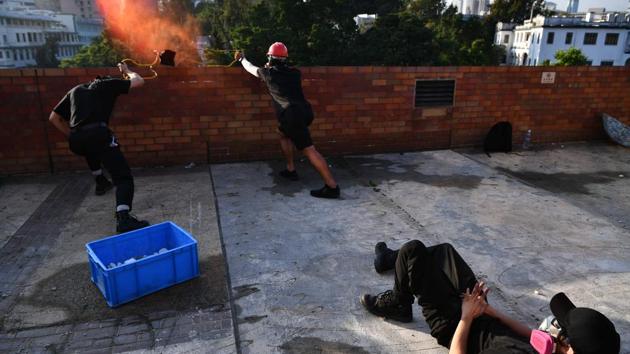 Protesters use a catapult to fire bricks at the police. “We are not afraid,” said a year-three student Ah Long, who chose not to disclose his full name. “If we don’t persist, we will fail. So why not (go) all in,” he said. (Anthony WALLACE / AFP) 