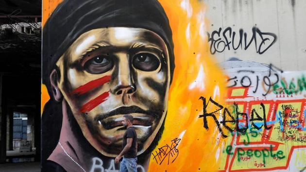 Street artist Hady Beydoun walks by his graffiti depicting the face of revolution in central Beirut. A majestic phoenix spreads its wings as Hayat Nazer adds a splash of colour to a Beirut wall. As Lebanon’s uprising enters its second month, graffiti has enveloped the capital’s posh downtown. Since October 17, the chanting of tens of thousands of Lebanese denouncing the political elite have shaken the normally staid district around two Beirut squares -- Martyrs’ and Riad Al Solh. (JOSEPH EID / AFP)
