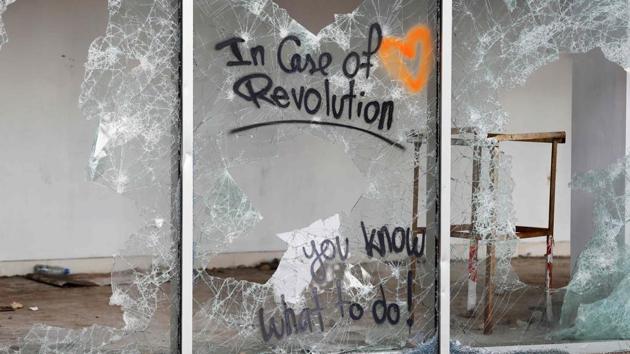 A graffiti is sprayed on a smashed glass facade. A ballerina pirouettes under shells, accompanied by the slogan “Rise up”. Further down, a big purple hand flashes a V for victory. On nearby buildings, various causes are championed with spray-painted and stencilled slogans: “Our revolution is feminist”; “LGBT rights, love is not a crime”; and “We will burn your palaces”. (JOSEPH EID / AFP)
