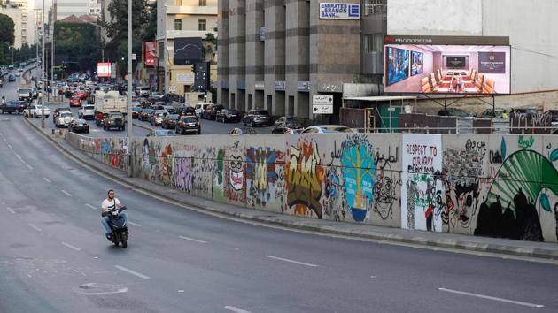 A man rides his motorcycle past a wall covered with graffitis. Nazer, a 32-year-old artist, is one of the protesters who would not normally frequent the area, famed for luxury boutiques and elegant buildings. But the unprecedented protests also offered her a first experience with street art. “I decided to go out in the street to be inspired by the people,” she said during a cigarette break, standing next to pots of red, green and yellow paint. (JOSEPH EID / AFP)