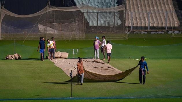 Groundkeepers cover the cricket pitch at Eden Garden to protect it from dew ahead of the first day-night Test match between India and Bangladesh.(PTI)