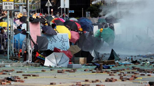 Protesters take cover under umbrellas as they are sprayed from a water cannon during clashes with police. Clashes between protesters and police have become increasingly violent in the Chinese-ruled city, which is grappling with its biggest political crisis in decades. The demonstrations pose the gravest popular challenge to Chinese President Xi Jinping since he came to power in 2012.  (Adnan Abidi / REUTERS) 