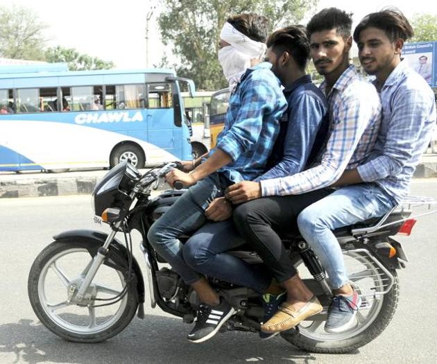 MULTIPLE VIOLATIONS, FATAL THRILLS: Four youth riding a motorbike without wearing helmets on Patiala-Sangrur road on Monday.(HT PHOTO)