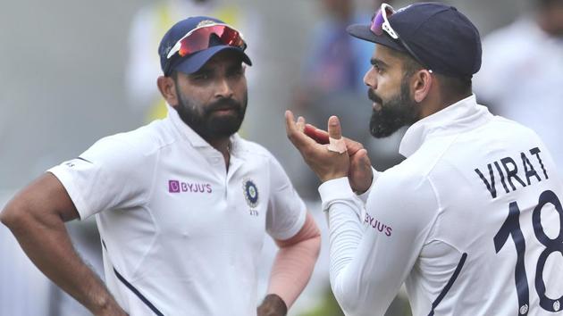 India's Mohammed Shami, left, watches captain Virat Kohli applaud teammates.(AP)