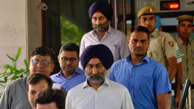 Former Ranbaxy Labs directors Malvinder Singh and Shivinder Singh being taken to a court in New Delhi in October.(Reuters File Photo)