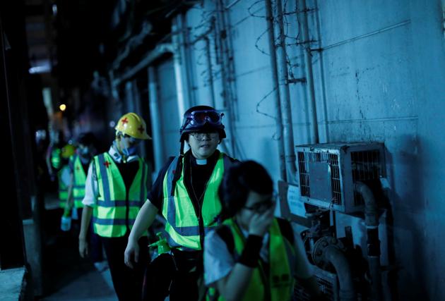 Pastor Alan Keung and first aid volunteers walk through an alley in order to avoid road blocks during an anti-government protest. “I am not someone who merely stays in the church and talks about humanity, justice and morality, and ignores what’s going on at the frontline,” Keung said. “This is not what I want to do. I want to show my companionship at the frontline and to be in the crowd when I’m needed.” (Kim Kyung-Hoon / REUTERS)