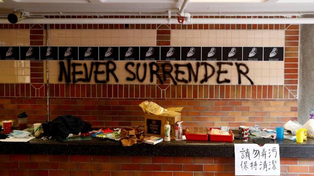 The slogan “Never Surrender” is spray painted on a wall in the besieged Hong Kong Polytechnic University (PolyU) in Hong Kong. Inside the increasingly empty and trashed campus of a Hong Kong university only a handful of activists held out on Thursday as they desperately searched for ways to escape or hide while squads of police encircled the grounds. (Thomas Peter / REUTERS)