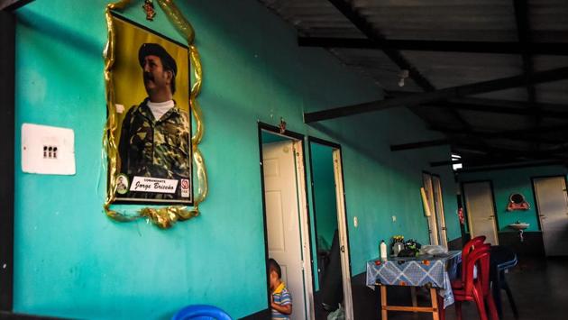 The son of a FARC-EP ex-combatant, walks in his house in La Montanita. The area is a former stronghold for the rebel group founded in the 1960s. It is also among the towns in Colombia with the most land mine victims. But now the home base of Humanicemos DH, an organization that helps former rebels who want to become professional deminers, director Angela Orrego said. (Juan Barreto / AFP) The son of a FARC-EP ex-combatant, walks in his house in La Montanita. The area is a former stronghold for the rebel group founded in the 1960s. It is also among the towns in Colombia with the most land mine victims. But now the home base of Humanicemos DH, an organization that helps former rebels who want to become professional deminers, director Angela Orrego said. (Juan Barreto / AFP)