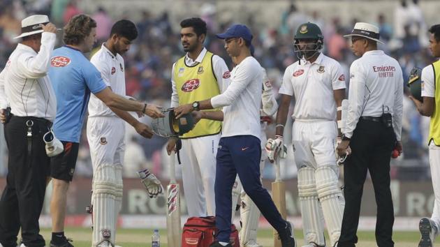 Bangladesh's Nayeem Hasan, third left, stands as physiotherapists of India and Bangladesh look.(AP)