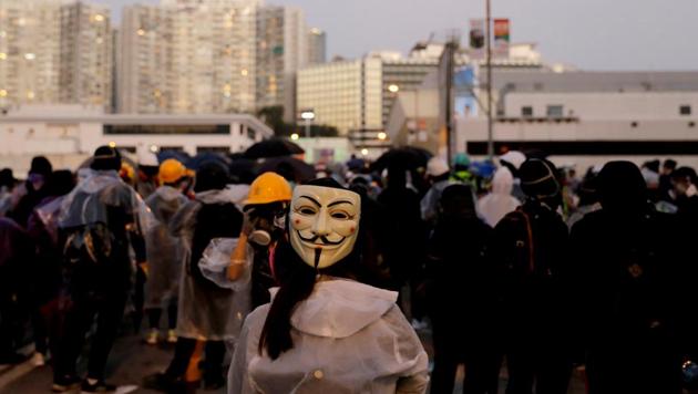 A protester wearing a Guy Fawkes mask stands on the bridge above the Cross Harbour Tunnel during clashes with police outside Hong Kong Polytechnic University (PolyU) in Hong Kong. (Photo: Reuters) A protester wearing a Guy Fawkes mask stands on the bridge above the Cross Harbour Tunnel during clashes with police outside Hong Kong Polytechnic University (PolyU) in Hong Kong. (Photo: Reuters)