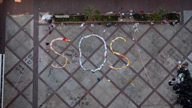 An “SOS” sign formed with clothes and helmets by protesters is seen inside the Hong Kong Polytechnic University campus in Hong Kong. Dozens of pro-democracy protesters stood firm within a besieged Hong Kong campus on Wednesday, where an “SOS” sign was laid out as police said they had made 700 arrests since the university became the epicentre of the most intense confrontation in the city’s near-six month crisis. (NICOLAS ASFOURI / AFP) An “SOS” sign formed with clothes and helmets by protesters is seen inside the Hong Kong Polytechnic University campus in Hong Kong. Dozens of pro-democracy protesters stood firm within a besieged Hong Kong campus on Wednesday, where an “SOS” sign was laid out as police said they had made 700 arrests since the university became the epicentre of the most intense confrontation in the city’s near-six month crisis. (NICOLAS ASFOURI / AFP)