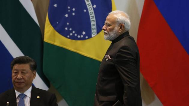 Prime Minister Narendra Modi walks past China's President Xi Jinping at the Leaders Dialogue with BRICS Business Council and the New Development Bank, at the Itamaraty Palace in Brasilia on November 14.(AP)