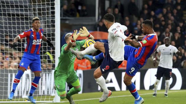 Crystal Palace goalkeeper Vicente Guaita, second left, Liverpool's Roberto Firmino and Crystal Palace's Jordan Ayew battle.(AP)