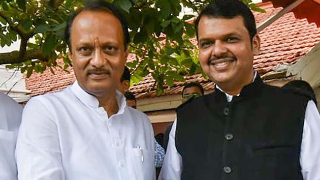 Newly-sworn in Chief Minister of Maharashtra Devendra Fadnavis shakes hands with his Deputy Chief Minister Ajit Pawar, in Mumbai onSaturday.(PTI PHOTO.)